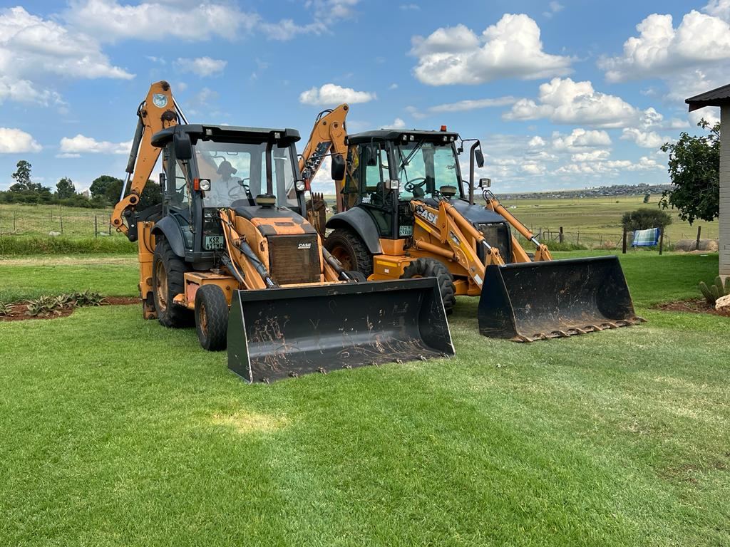 Two Paul Plant Hire backhoe loaders parked on site